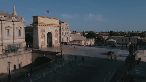 Blick-Auf-Fahrende-Autos-Und-Passanten-Am-Arc-De-Triomphe-In-Montpellier,-Frankreich-An-Einem-Sonnigen-Tag