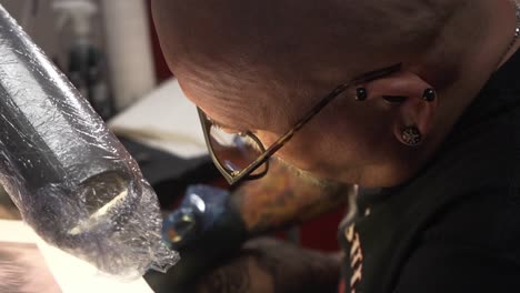 Tattoo-artist-tattooing-someone-his-arm
