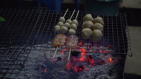 Close-up-of-preparing-grilled-BBQ-pork-in-wooden-skewers-using-charcoal-heat