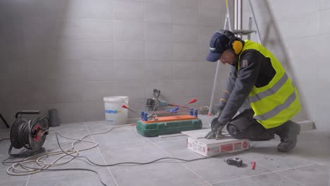 Slowmotion-shot-of-a-worker-using-an-angle-grinder-to-cut-a-tile-on-a-building-site