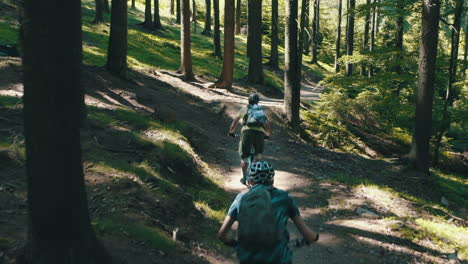A-group-of-three-men-riding-mountain-bikes-fast-down-the-trail---cinematic-moving-camera-shot