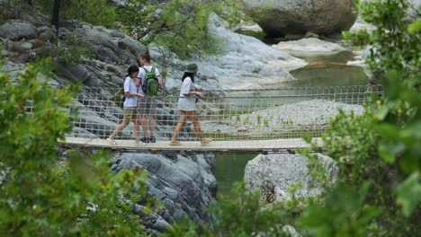 tourists-are-crossing-the-suspension-bridge-over-the-river