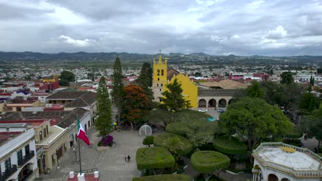 frontal-drone-shot-of-Comitan,-Chiapas,-Mexico-main-plaza-during-sunset