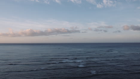 Olas-Tranquilas-Y-Nubes-Coloridas-Al-Amanecer,-Playa-De-Waikiki,-Tiro-Aéreo