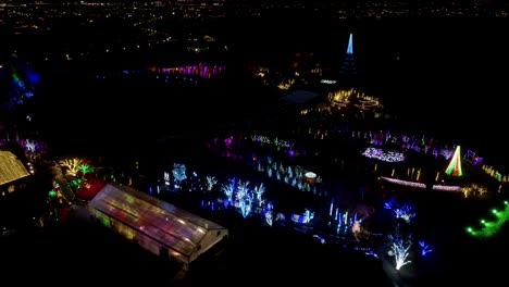 Christmas-festival-at-a-garden-park---aerial-parallax-view-at-nighttime