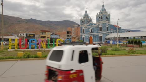 Huanuco-city-center-with-rickshaw-driving-around-the-main-square-with-blue-cathedral