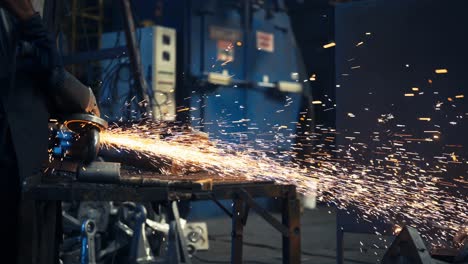 Factory-Worker-is-Welding-in-Protective-Helmet-and-glasses,-Sparks-fly-from-hot-metal
