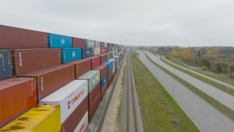 Aerial-view-of-many-empty-metal,-rusted,-and-colored-sea-containers-lined-up-in-a-port-terminal