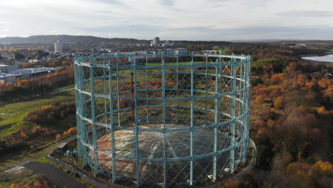 Rotating-drone-shot-of-a-disused-Gasometer-on-the-city's-outskirts-in-Edinburgh