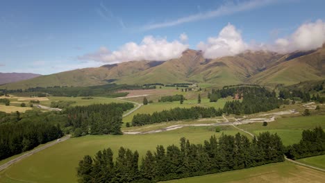 Lush-foothills-of-southern-alps-of-New-Zealand-with-a-highway-leading-towards-the-mountains