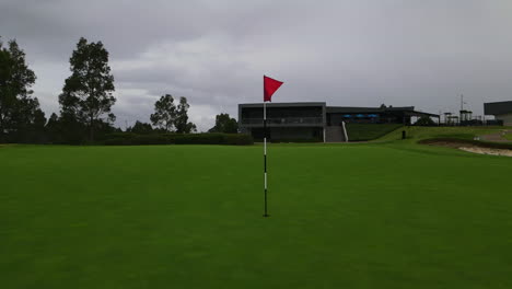 Rote-Golfmastfahne-Auf-Gepflegtem-Grün-Am-Golfplatz-Mit-Bunker-Pt-3