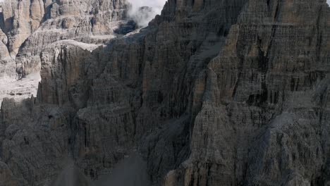 Epic-drone-shot-of-rocky-mountain-face-wall-during-sunny-day-in-Italian-Dolomites