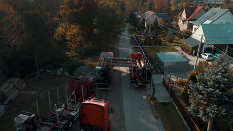 Aerial-view-of-timber-trucks-loading-tree-logs-on-the-street