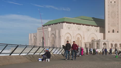 Moroccan-people-walking-in-front-of-Hassan-II-mosque-Casablanca-Morocco