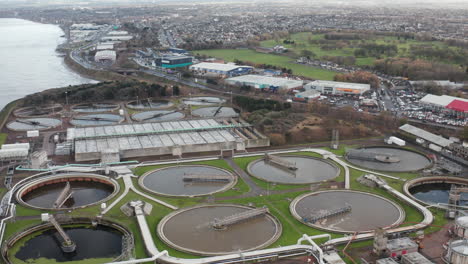 Panning-aerial-shot-of-a-large-sewage-plant-with-a-vast-city-in-the-background