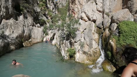 People-swim-at-spring-water-pool-in-canyon