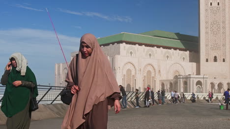 Muslim-familiy-walking-in-front-of-Hassan-II-mosque-Casablanca-Morocco