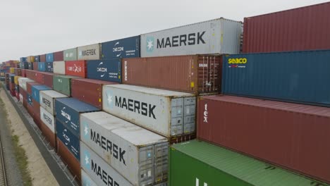 Luftbild-Vieler-Leerer,-Verrosteter-Und-Farbiger-Seecontainer-Aus-Metall,-Die-In-Einem-Hafenterminal-Aufgereiht-Sind