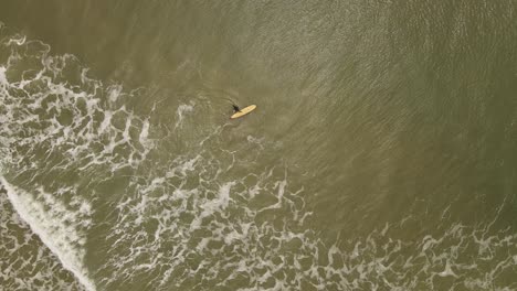 Ein-Männlicher-Surfer,-Der-Mit-Seinem-Brett-Am-La-Pedrera-Beach-In-Uruguay-In-Die-Brandung-Des-Atlantiks-Eindringt