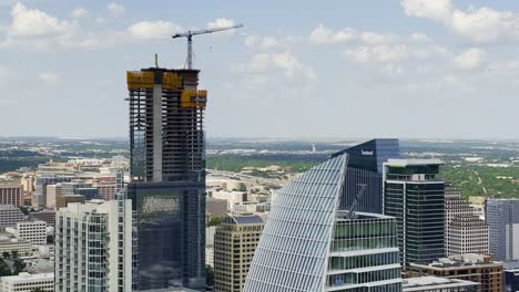 Aerial-view-around-high-rise-construction-in-sunny-Austin,-USA---circling,-drone-shot