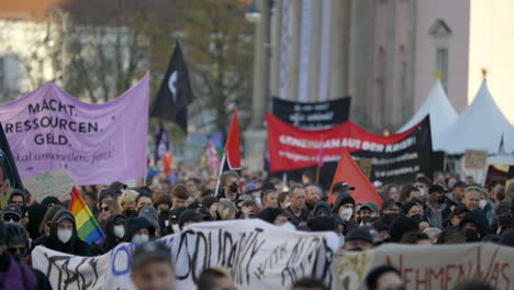 Huge-crowd-of-protesters-marching-in-berlin-with-flags-and-banners-in-economic-inflation-demonstration,-Slow-motion