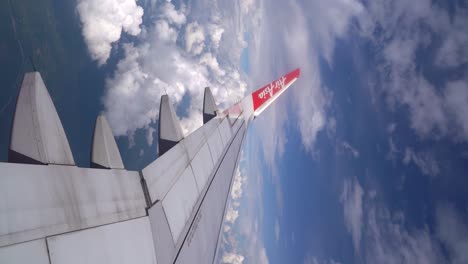 Vertical-view-of-Air-Asia-airplane-wing-flying-through-blue-sky