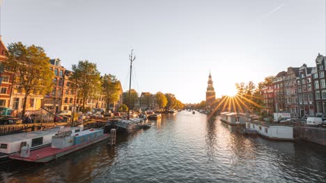 4K-Dreamy-and-Moody-Time-lapse-of-golden-hour-on-Amsterdam-Canal-with-many-moving-boats-and-tower,-panoramic-view