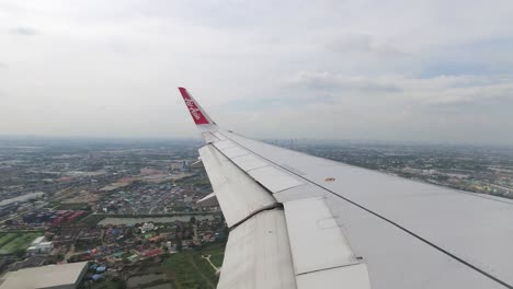 Airplane-landing-toward-Bangkok,-Thailand-on-cloudy-day