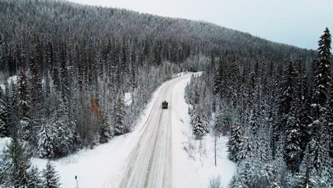 Ein-Schwarzer-Pickup-Truck,-Der-Auf-Dem-Schneebedeckten-Little-Fort-Highway-24-Durch-Einen-Dichten-Nadelwald-Im-Wunderschönen-British-Columbia,-Kanada,-Friedliches-Wintererlebnis-Und-Wunderschöne-Natur-Fährt