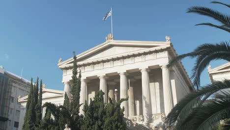 Plano-Exterior-De-La-Bandera-Griega-Ondeando-Sobre-El-Edificio-De-La-Biblioteca-Nacional-De-Atenas