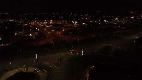 Night-flying-above-UK-town-highway-with-illuminated-street-lights-and-McDonalds-advertising-logo-aerial-view