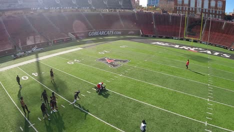 FPV-drone-shot-of-a-american-football-training-inside-the-Nippert-Stadium,-at-the-University-of-Cincinnati,-USA