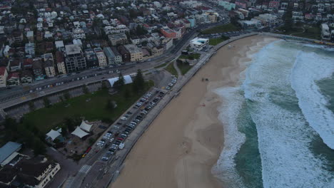 Drone-shot-along-Bondi-beach-with-waves-lapping-and-clear-beach