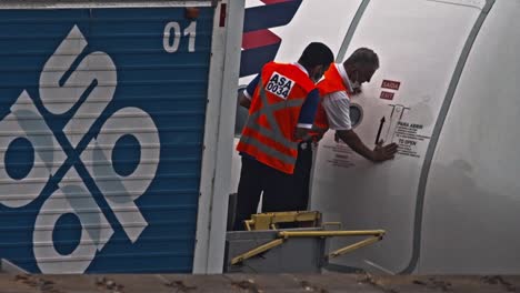 Ground-crew-at-an-airport-locks-the-aircraft-door-for-takeoff