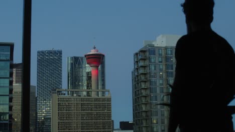 man-watching-Calgary-Tower-from-apartment