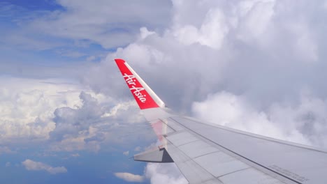 Vista-Interior-Del-Ala-De-Aire-Asiático-Volando-A-Través-Del-Cielo-Nublado