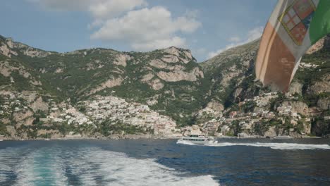 Transbordador-Navegando-En-La-Costa-Italiana-Con-Retrolavado-Y-Paisaje-Montañoso-Rocoso-En-El-Fondo-Durante-El-Verano