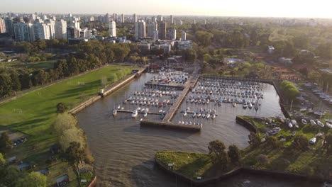 Aerial-view-of-Olivos-Yacht-Club-during-sunset-time-with-Buenos-Aires-Cityscape-in-background