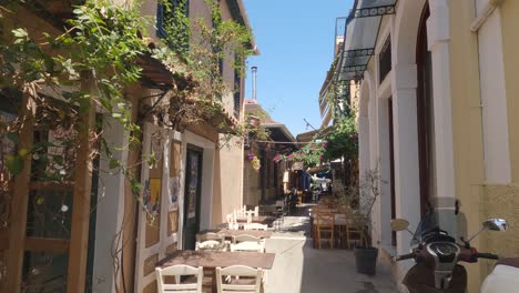 People-walking-down-a-picturesque-alley-with-restaurant-and-cafes-in-Preveza,-Greece