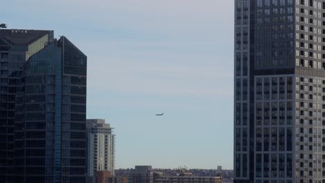 Commercial-airplane-flying--between-building-towers