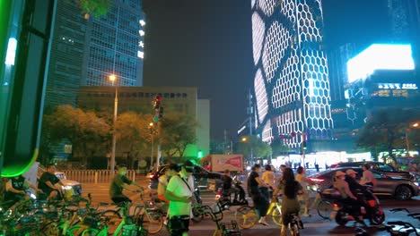 Peking-Sanlitun-4k---Belebte-Straßen-Bei-Nacht-Mit-Menschen,-Die-Fahrräder-Fahren,-Und-Wunderschöne-Skyline