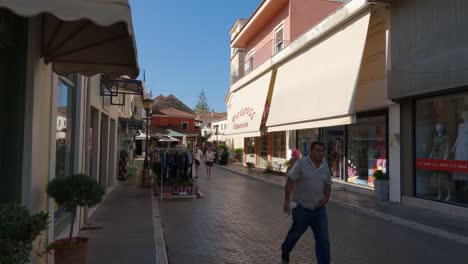 Tracking-shot-of-a-tourist-walking-down-a-shopping-street-in-Preveza,-Greece