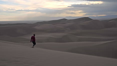 Girl-walks-across-windy-dune-in-Great-Sand-Dunes-National-Park-Colorado