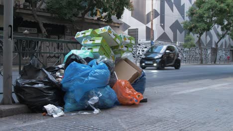 People-and-traffic-pass-by-rubbish-on-the-roadside-in-Athens