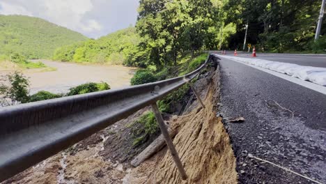 Camino-Asfaltado-A-Lo-Largo-Del-Río-Dañado-Por-Inundaciones-Repentinas-Y-Fuertes-Lluvias-En-La-Provincia-De-Chiang-Mai,-Tailandia