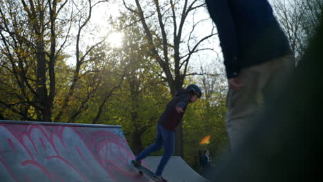 Full-shot-of-skater-kid-dropping-down-ramp-at-local-skatepark,-slow-motion