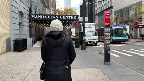 Warm-dressed-female-rear-view-walking-towards-Manhattan-center-Hammerstein-ballroom-entrance-in-New-York-city