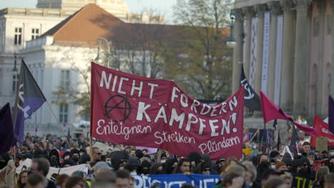 Slow-motion-German-crowd-protesting-social-economic-situation-with-flags-and-banners-in-Berlin