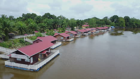 Drone-view-of-floating-red-villas-in-Rompin-Pahang-river,-Malaysia