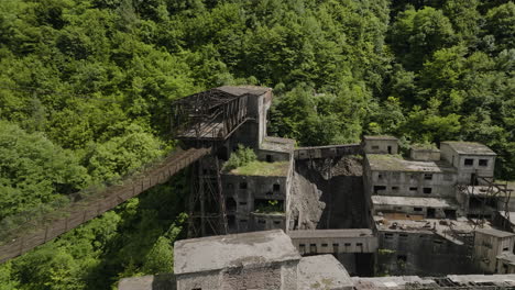 Rusty-freight-cableway-platform-and-ruined-factory-buildings,-Georgia